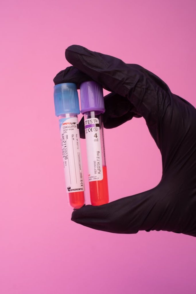 Unrecognizable laboratory worker showing blood test tubes